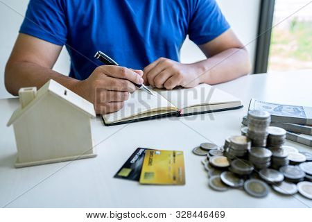 Man Writing Report To Planning Growing Saving To Strategy With Money Box For Future Plan Fund Of Tra
