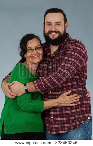 Portrait Of Larina Son And Mother Isolated On Gray Studio Background