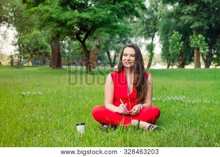 Portrait Of Young Smiling Business Woman In Red Suit In Earphones, Doing Online Learning Cources And