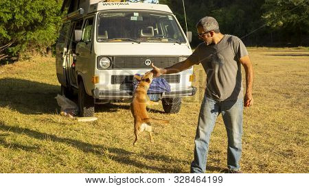 Encuentro Park, Chiapas, Mexico - Mar 23rd , 2018: Man Playing With Dog And A Camper Van
