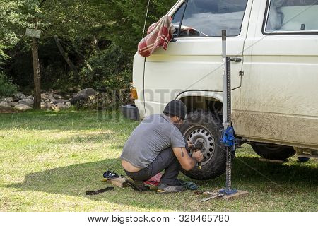 Encuentro Park, Chiapas, Mexico - May14th , 2018: Mechanic Changing Wheel In A Classic Camper Van At