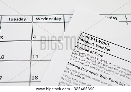 Irs Form 941-v Payment Voucher Blank Lies On Empty Calendar Page