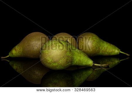 Group Of Four Whole Fresh Green Pear Isolated On Black Glass
