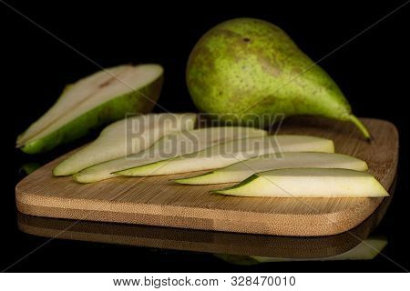 Group Of One Whole One Half Five Slices Of Fresh Green Pear On Bamboo Cutting Board Isolated On Blac