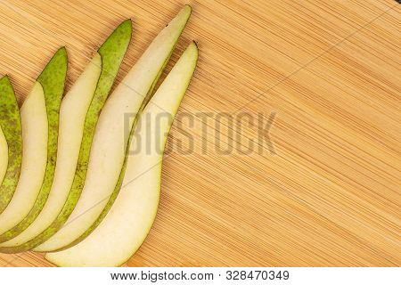 Group Of Five Slices Of Fresh Green Pear Flatlay On Light Wood