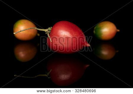 Group Of Three Whole Fresh Tomato De Barao One With Stem Isolated On Black Glass