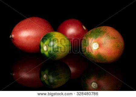 Group Of Four Whole Fresh Tomato De Barao Front Focus Isolated On Black Glass
