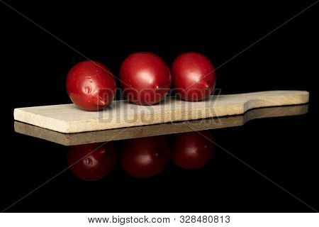 Group Of Three Whole Fresh Tomato De Barao On Wooden Cutting Board Isolated On Black Glass