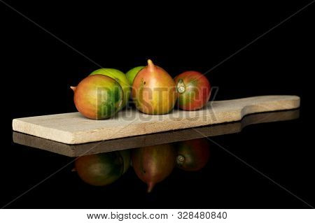Group Of Five Whole Fresh Tomato De Barao On Wooden Cutting Board Isolated On Black Glass