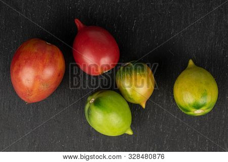 Group Of Five Whole Fresh Tomato De Barao Flatlay On Grey Stone