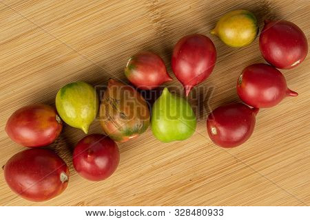 Group Of Twelve Whole Fresh Tomato De Barao Flatlay On Light Wood
