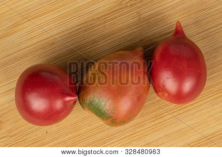Group Of Three Whole Fresh Tomato De Barao Flatlay On Light Wood
