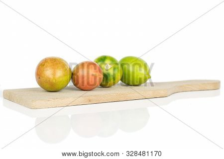 Group Of Four Whole Fresh Tomato De Barao On Wooden Cutting Board Isolated On White Background
