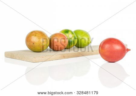 Group Of Five Whole Fresh Tomato De Barao On Wooden Cutting Board Isolated On White Background