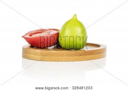 Group Of One Whole One Half Of Fresh Tomato De Barao On Round Bamboo Coaster Isolated On White Backg