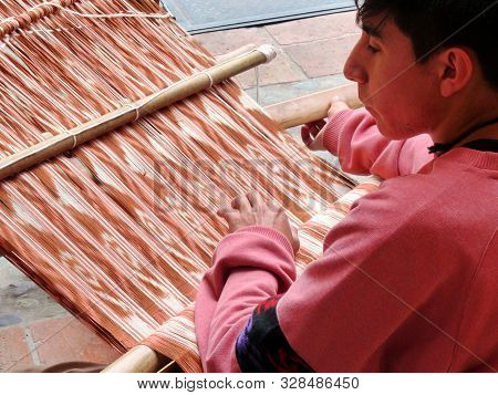 Cuenca, Ecuador - March 8, 2019: Ecuadorian Man Is Weaving Scarf Or Macana By Hand With Cotton Threa