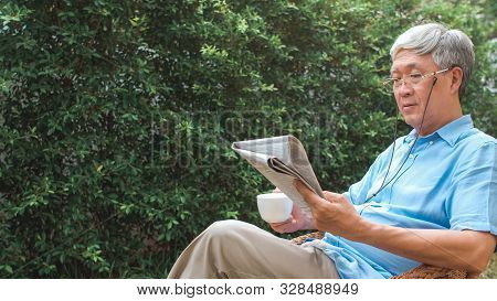 Asian Senior Men Relax At Home. Asian Senior Chinese Male Enjoy Rest Time Wear Glasses Read Newspape