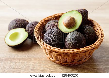 Fresh Ripe Hass Avocado Fruit In Basket On Wooden Background