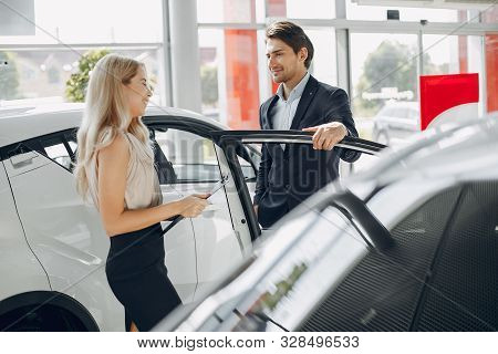 Stylish And Elegant Couple In A Car Salon