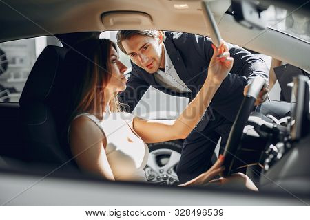 Stylish And Elegant Couple In A Car Salon