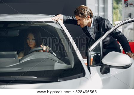 Stylish And Elegant Couple In A Car Salon