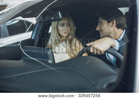 Stylish And Elegant Couple In A Car Salon