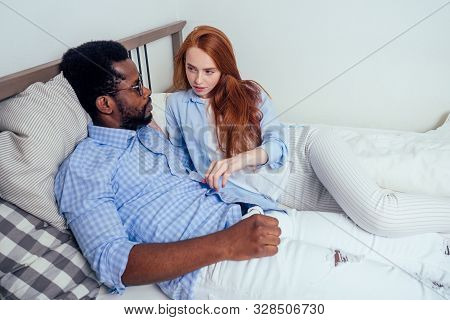 Redhaired Ginger Caucasian Happy Female And Multi-ethnic Afro Man Together Lying In Bed Bedroom.life