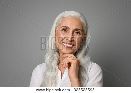 Portrait Of Beautiful Mature Woman On Grey Background
