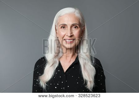 Portrait Of Beautiful Mature Woman On Grey Background