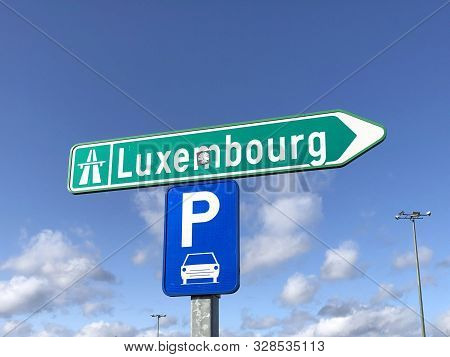 Liège, Belgium - October 19, 2019: Green Highway Direction Sign And Blue Parking Logo Against A Part