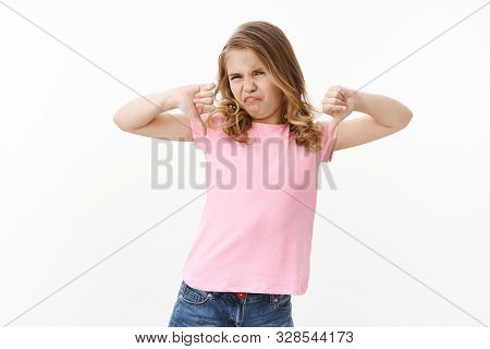 Moody Picky Ignorant Blond Little Girl Kid, Show Thumbs Down Frowning, Grimacing Aversion And Disapp