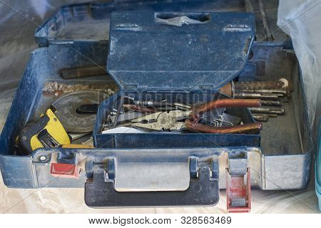 A Box With Old Tools Strewn With White Construction Dust.