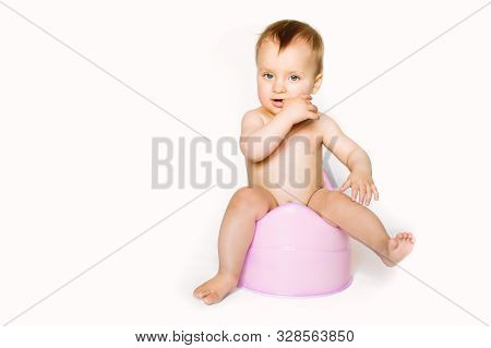 Baby Girl Sits On A Childrens Pot, Toilet On A White Background