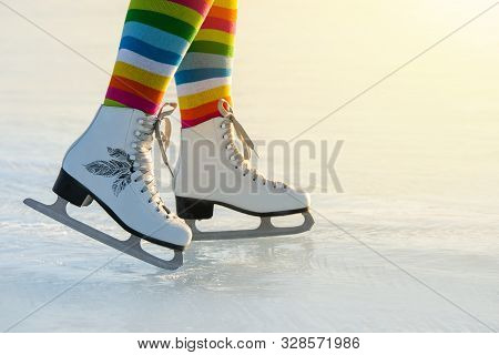 Pair Of Legs Shod Ice Skates On Ice In Winter