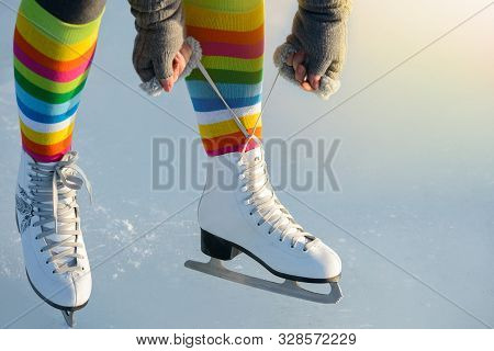 Pair Of Legs Shod Ice Skates On Ice In Winter