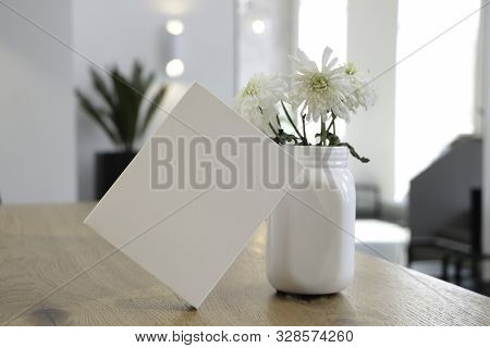 The Box Is On The Table. White Box. On The Background Of The Cafe. Flowers And White Box