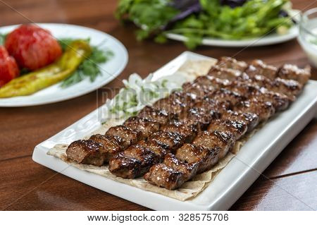 Fast food. Eastern food. Shish kebab, lyulya-kebab. Dishes of oriental cuisine lying in plte and dec