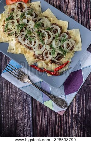 Beshbarmak Is A National Tatar Dish - Square Pasta With Boiled Meat And Onions. On A Black Backgroun