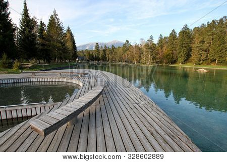 Wooden Pier Over The Emerald Waters Of A Lake