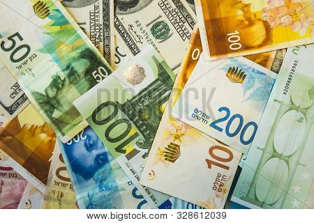 Dollars, Euros And Israeli New Shekels Are Lying Chaotically On The Table.