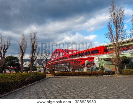 Japan, Kobe - April 10, 2017: Dark Clouds Over Large Red Bridge That Spans Over Kobe Port In Japan