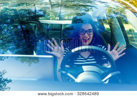 Woman In A Self-driving Autonomous Electric Vehicle With Hands Off The Steering Wheel