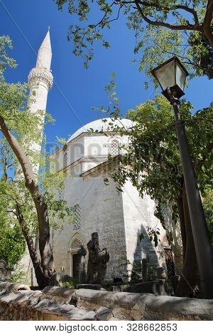 Karadoz Bey Mosque, Located On Brace Fejica Street, With A Street Lamp In The Foreground, Mostar, Bo