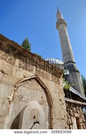 Karadoz Bey Mosque, Located On Brace Fejica Street, With A Fountain And Carvings In The Foreground, 