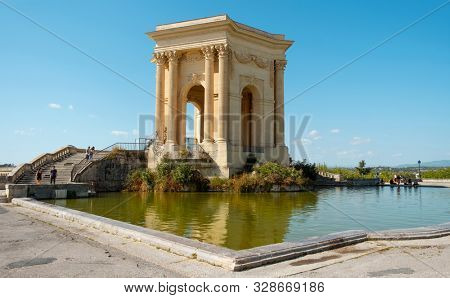 MONTPELLIER, FRANCE - SEPTEMBER 19, 2019: A view of the Promenade du Peyrou garden in Montpellier, France, highlighting the Chateau de eau, its iconic neoclassical water tower, presiding over the pond