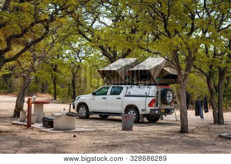 Halali, Namibia - March 27, 2019 : Tent Located On The Roof Of A Pickup 4x4 Car Parked Under Trees O