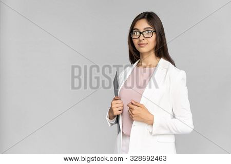 Smiling Young Adult Indian Professional Business Lady In White Formal Wear Standing Isolated On Grey