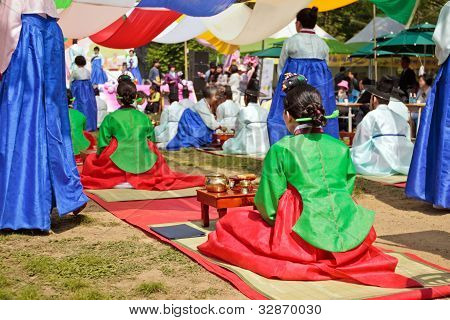 En kvinder i traditionel koreansk kjole (hanbok) i te ceremoni