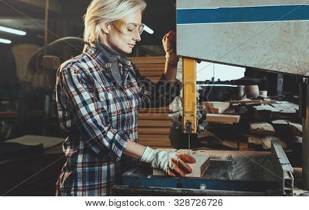 Middle Aged Woman Working With A Drill In Workshop. Concept Of Woman In A Male-dominated Profession,