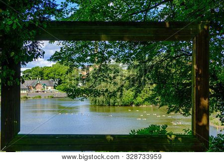 View Through Large Hollow Picture Frame Of Trees And Birds In Pond At Leases Park In Newcastle, Engl